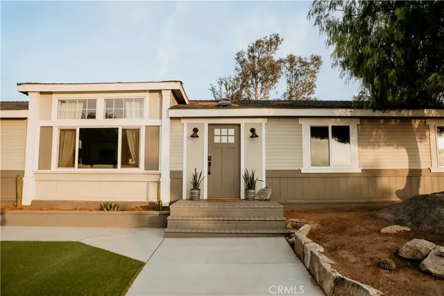 a front view of a house with a yard and trees