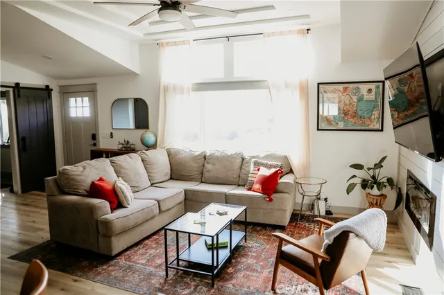 a living room with furniture a flat screen tv and a fireplace