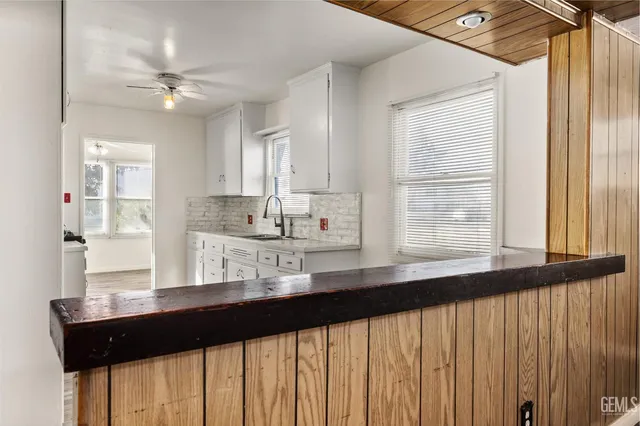 a kitchen with kitchen island a sink appliances cabinets and a large window