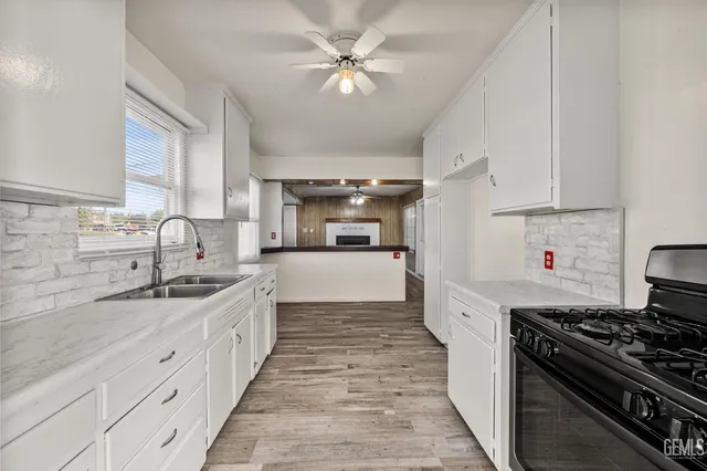 a kitchen with stainless steel appliances a sink stove and cabinets