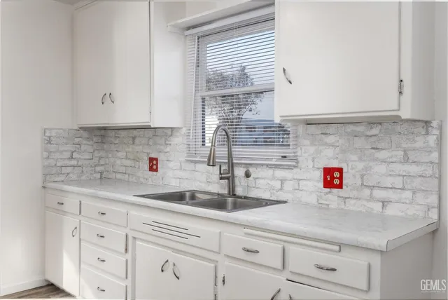 a kitchen with white cabinets and a sink