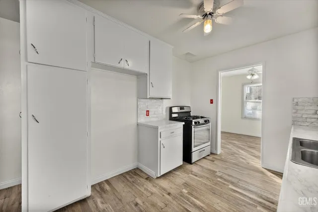 a kitchen with white cabinets and white appliances