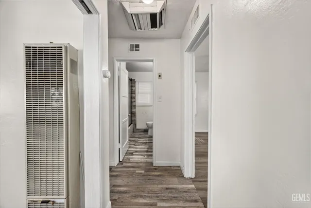 a view of a hallway with wooden floor and entryway
