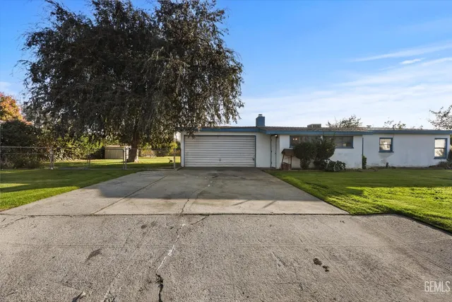 a front view of a house with a yard and a garage
