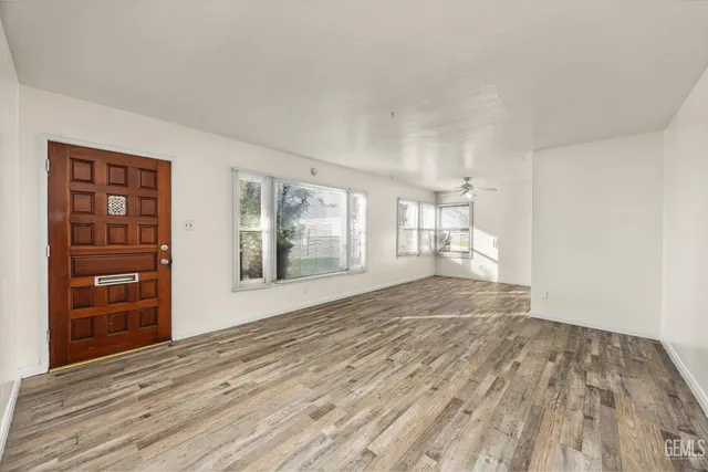 a view of empty room with wooden floor