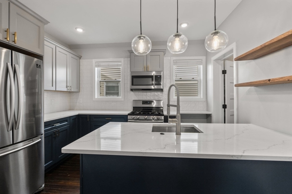 101 Draper Street, Unit 2 Boston, MA 02122 - Photo 3 of 19 a kitchen with cabinets a refrigerator a stove and a sink
