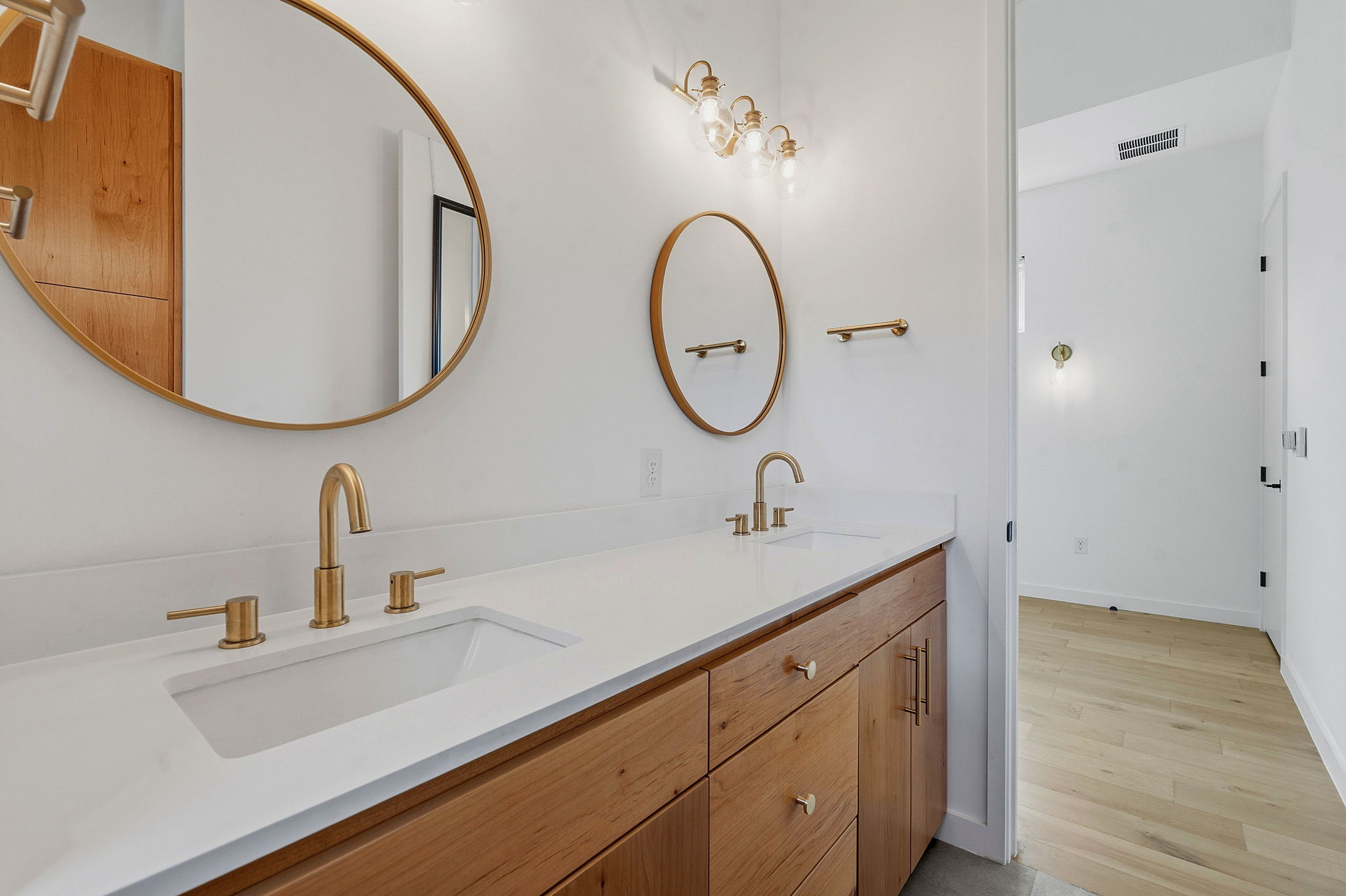 1707 Deloney Street, Unit 2 Austin, TX 78721 - Photo 17 of 26 Polished gold fixtures gleam against a pristine double vanity in this modern bathroom.