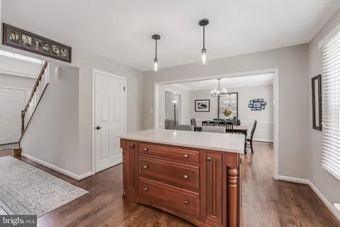a large kitchen with stainless steel appliances granite countertop a refrigerator a sink dishwasher a stove and white cabinets with wooden floor