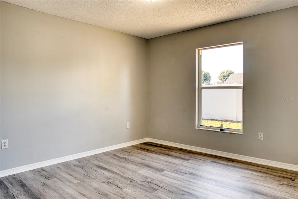 1447 Kingston Way Kissimmee, FL 34744 - Photo 11 of 24 an empty room with wooden floor and a window