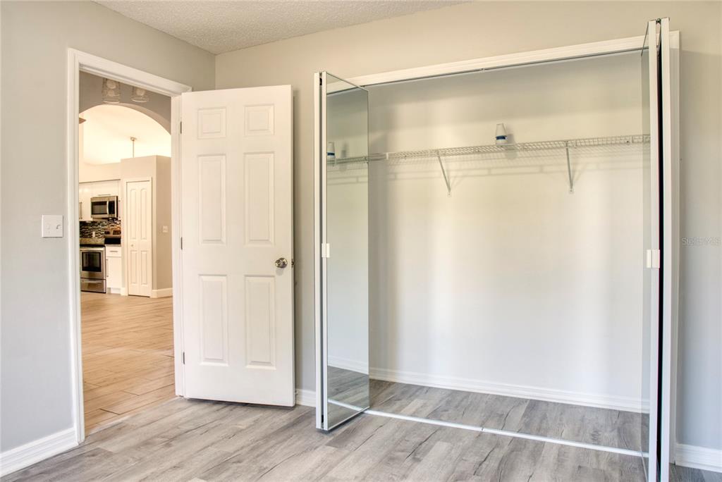 1447 Kingston Way Kissimmee, FL 34744 - Photo 14 of 24 a view of an empty room with wooden floor and a bathroom