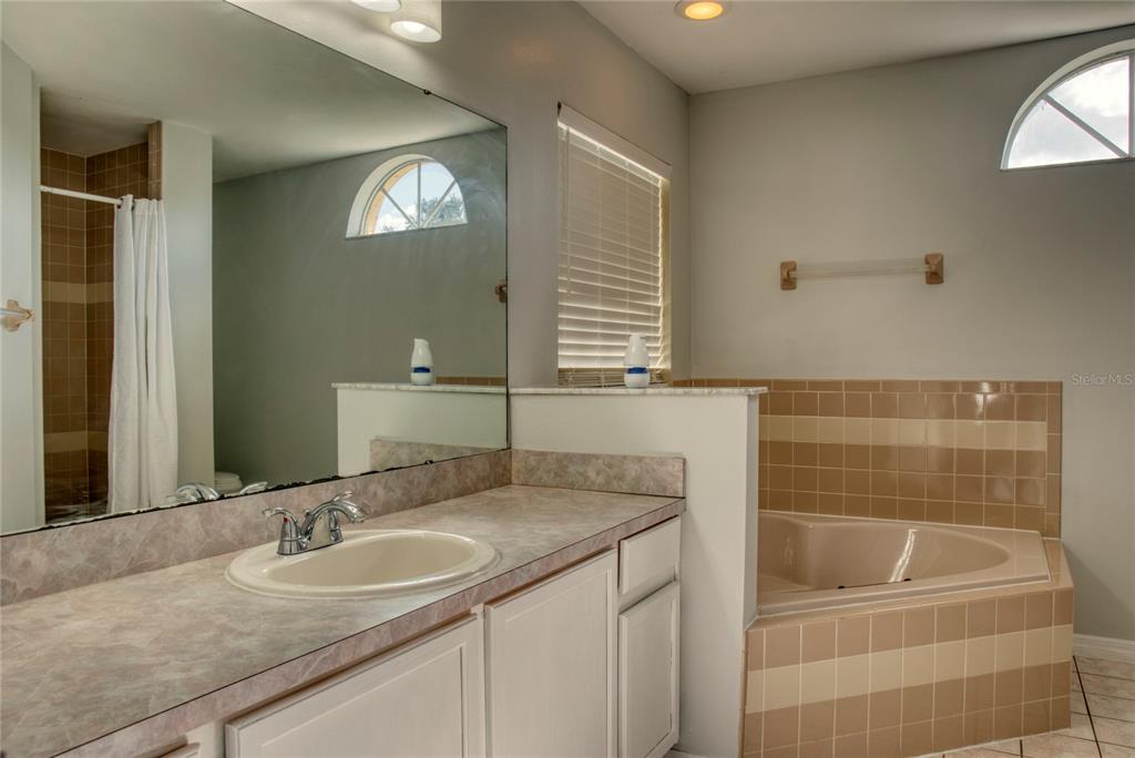 1447 Kingston Way Kissimmee, FL 34744 - Photo 18 of 24 a bathroom with a granite countertop sink a toilet and mirror
