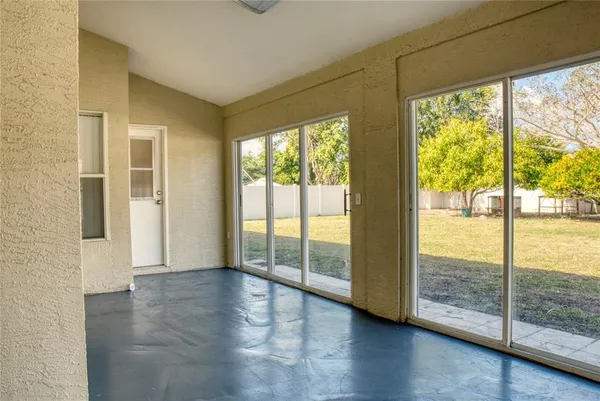 a view of an empty room and wooden floor and a window