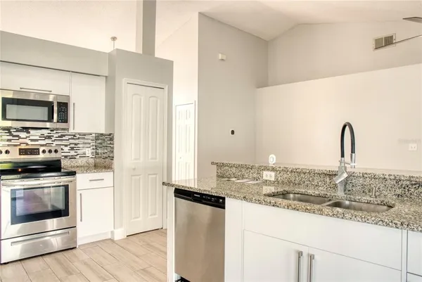 a kitchen with granite countertop a sink and stainless steel appliances