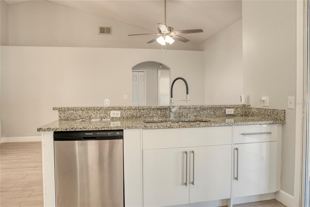 1447 Kingston Way Kissimmee, FL 34744 - Photo 10 of 24 a kitchen with granite countertop white cabinets and chandelier