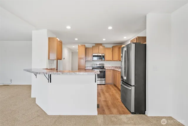 a kitchen with stainless steel appliances kitchen island sink refrigerator and microwave