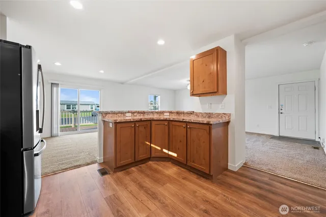 a kitchen with granite countertop a refrigerator and a stove top oven