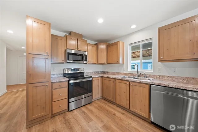 a kitchen with granite countertop stainless steel appliances and wooden cabinets