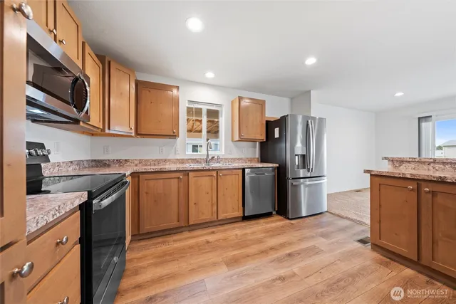 a kitchen with refrigerator a sink and wooden cabinets