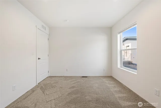 an empty room with windows and closet