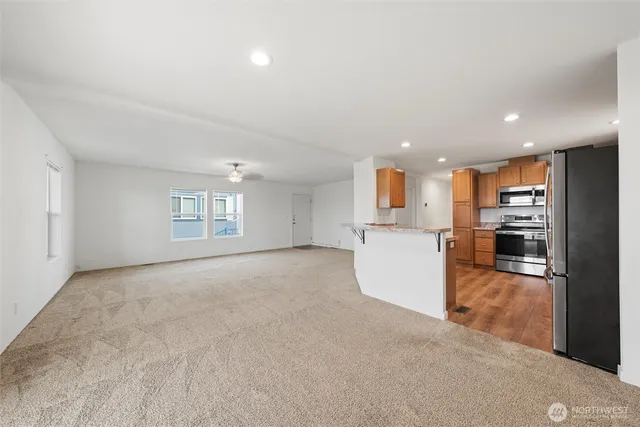 an empty room with kitchen appliances and windows