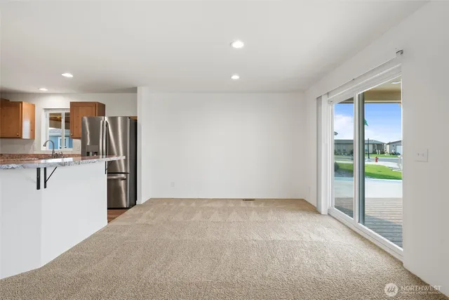 a view of kitchen with refrigerator and countertop cabinets