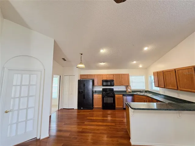 a kitchen with stainless steel appliances granite countertop a refrigerator and a stove top oven