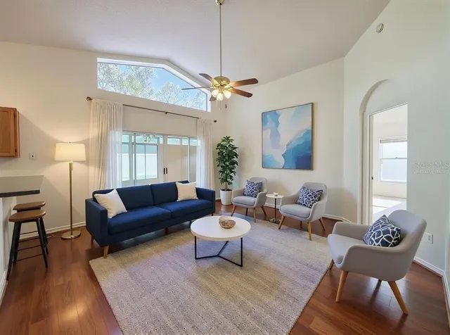 a living room with furniture a chandelier and a rug