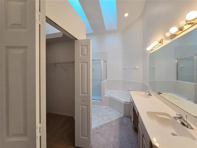 a spacious bathroom with a tub sink and mirror