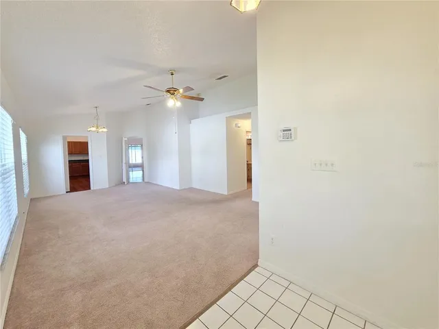 a view of a hallway with a chandelier fan and windows
