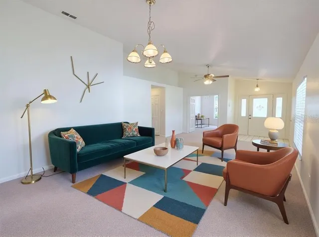 a living room with furniture a chandelier and a dining table