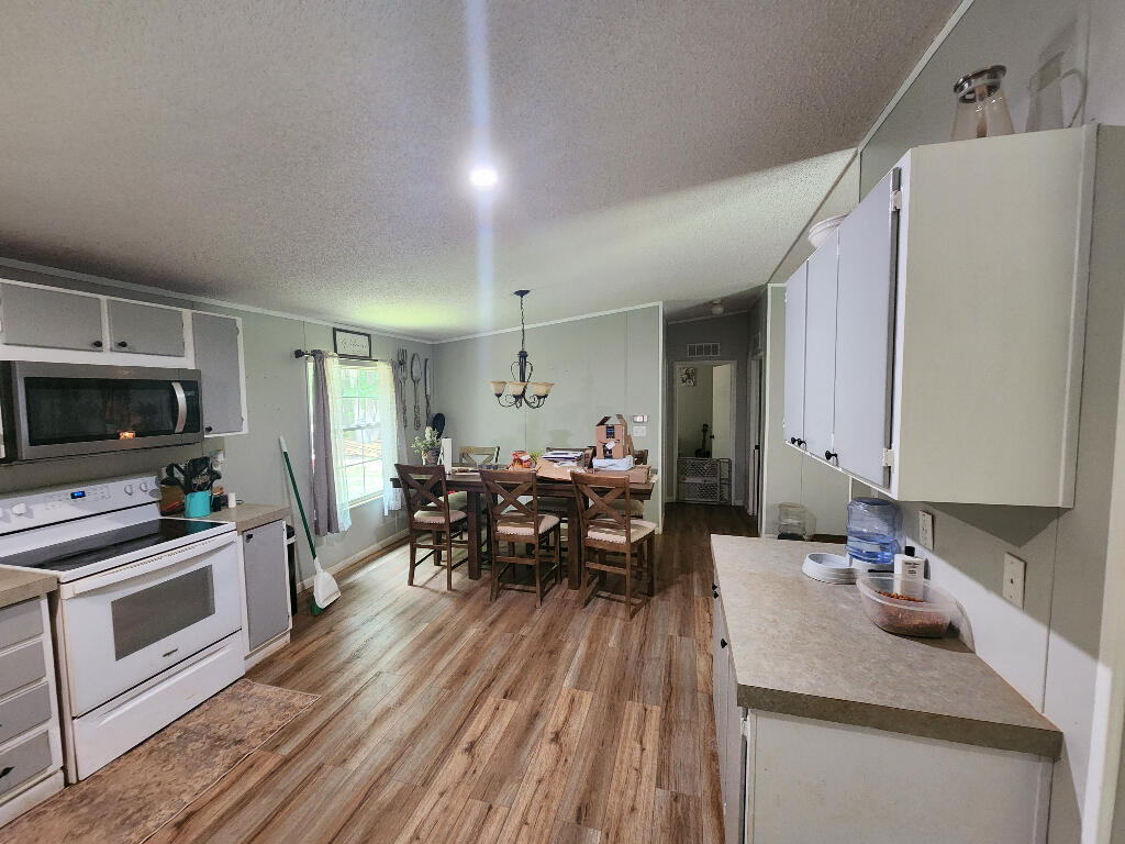 3171 Neals Corner Road Clover, VA 24534 - Photo 2 of 6 a kitchen with sink cabinets and wooden floor