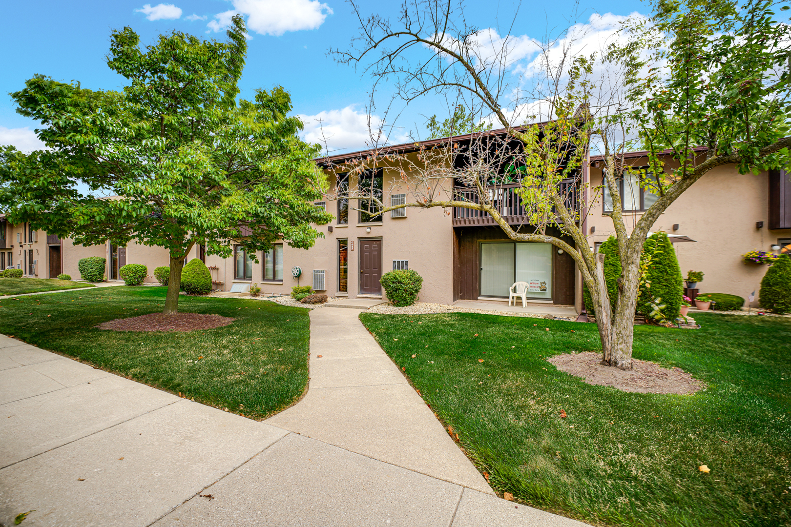 1100 Holbrook Road, Unit D Homewood, IL 60430 - Photo 2 of 16 a view of a white house next to a yard with big trees