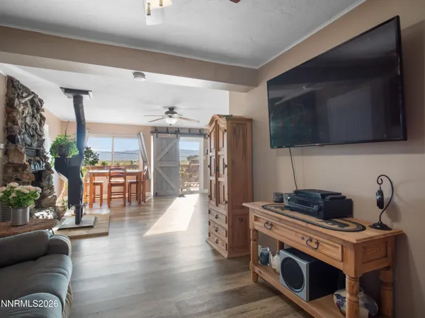 a kitchen with stainless steel appliances a stove a refrigerator a sink a dining table and chairs with wooden floor