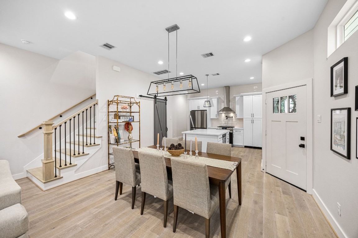 317 Sikes Street Houston, TX 77018 - Photo 14 of 30 Bright open-concept dining area with high ceilings, stylish lighting, and view to kitchen and stairs.