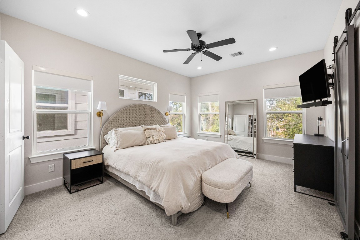 317 Sikes Street Houston, TX 77018 - Photo 19 of 30 Tranquil primary suite with ceiling fan, custom window coverings, and view of backyard.