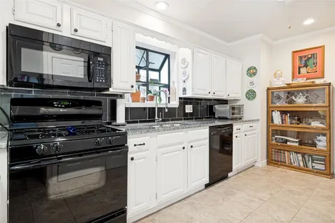 a kitchen with stainless steel appliances granite countertop a stove and cabinets