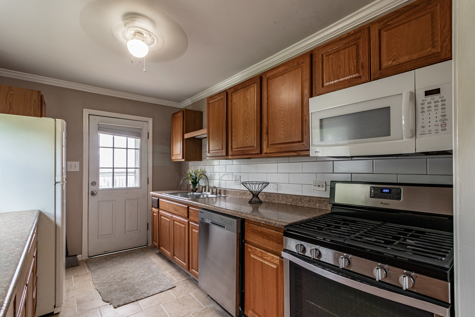 18229 West Big Oaks Road Grayslake, IL 60030 - Photo 10 of 22 a kitchen with stainless steel appliances a stove sink microwave and cabinets