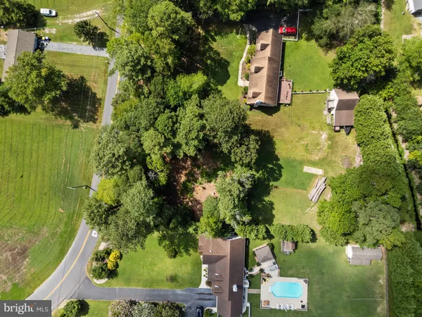 an aerial view of residential house with outdoor space and trees all around