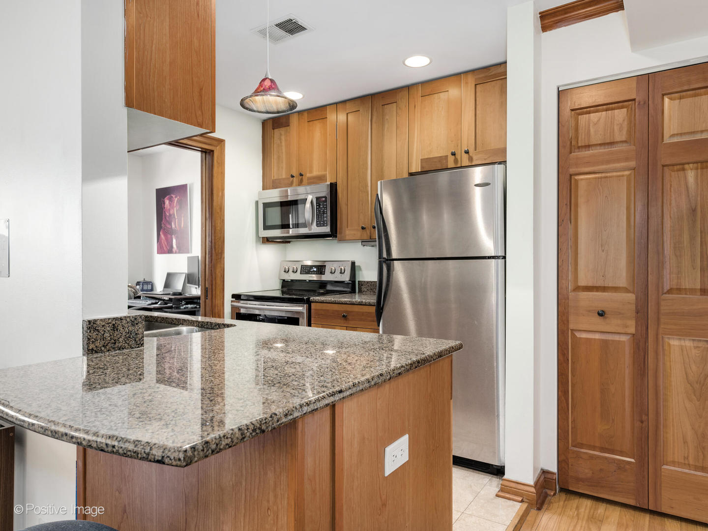 512 West Barry Avenue, Unit 312 Chicago, IL 60657 - Photo 5 of 12 a kitchen with kitchen island granite countertop a refrigerator a stove top oven a sink and dishwasher