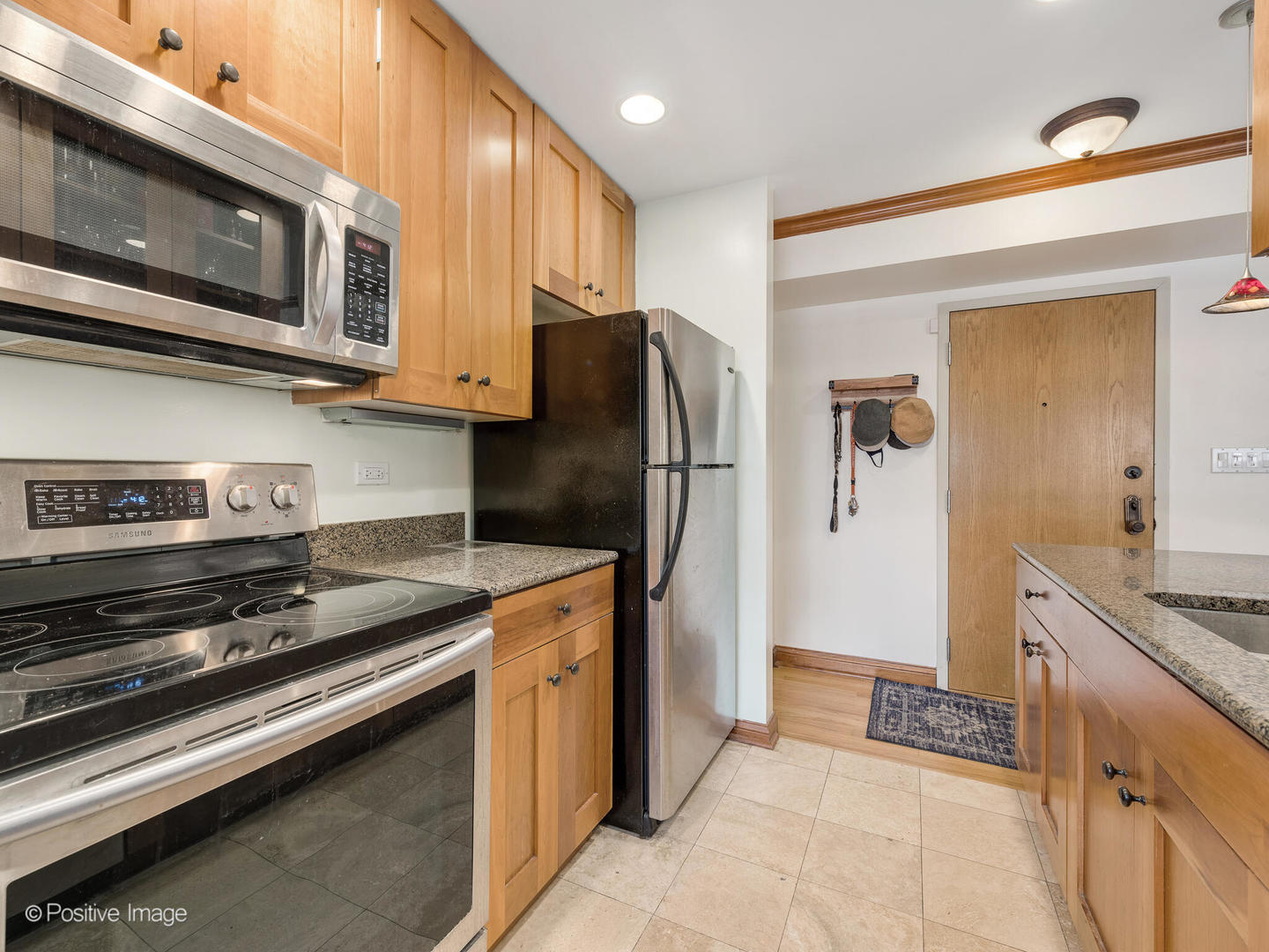 512 West Barry Avenue, Unit 312 Chicago, IL 60657 - Photo 7 of 12 a kitchen with stainless steel appliances granite countertop a refrigerator and a stove