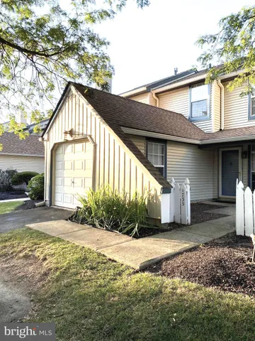 a front view of a house with a yard and potted plants