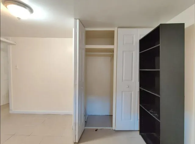 a view of a kitchen with refrigerator and white cabinets