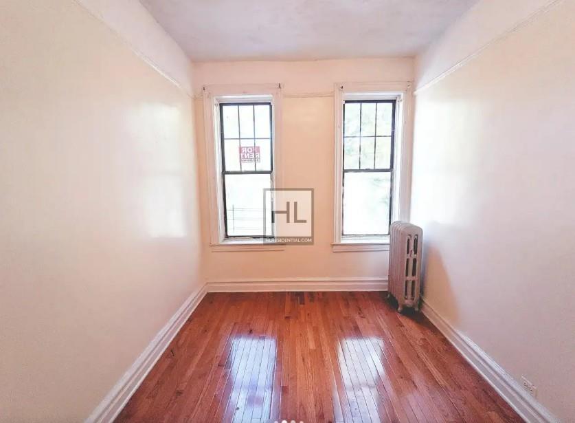 354 Rutland Road Brooklyn, NY 11225 - Photo 4 of 50 an empty room with wooden floor and windows