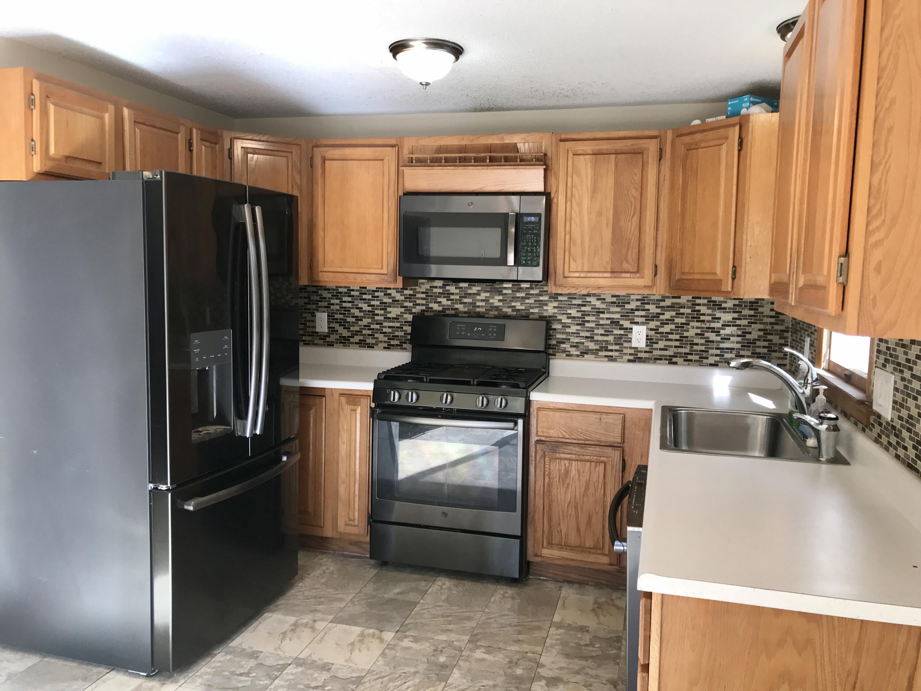 24 Papnomett Road Mashpee, MA 02649 - Photo 5 of 28 a kitchen with a refrigerator and a sink