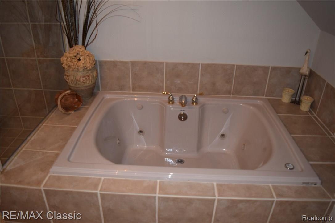 12825 Larkins Road Brighton, MI 48114 - Photo 31 of 39 Lower level bath features jetted tub and separate shower.