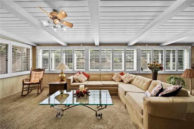 a living room with furniture and floor to ceiling windows