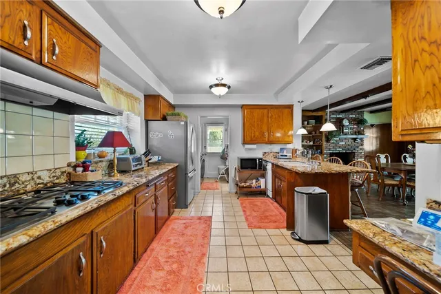 a kitchen with stainless steel appliances granite countertop a stove a sink dishwasher and cabinets with wooden floor