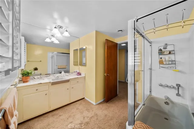 a bathroom with a double vanity sink mirror and shower