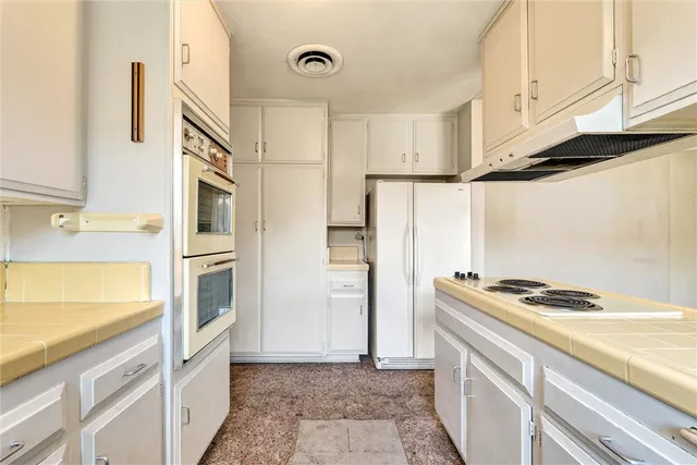 a kitchen with stainless steel appliances granite countertop a refrigerator and a stove