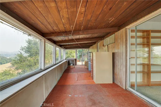 a view of a porch with furniture and a yard